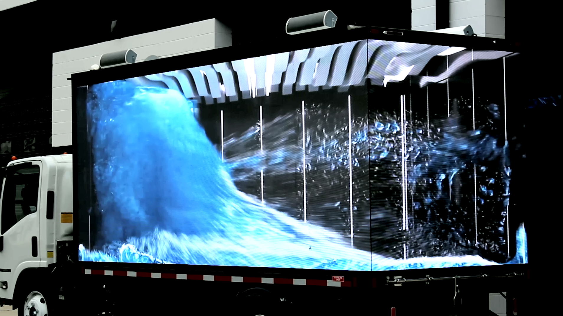 Non-3D AI video displayed across two abutting LED billboard truck screens. While not actually 3D, the seamless screens create a 3D appearance.