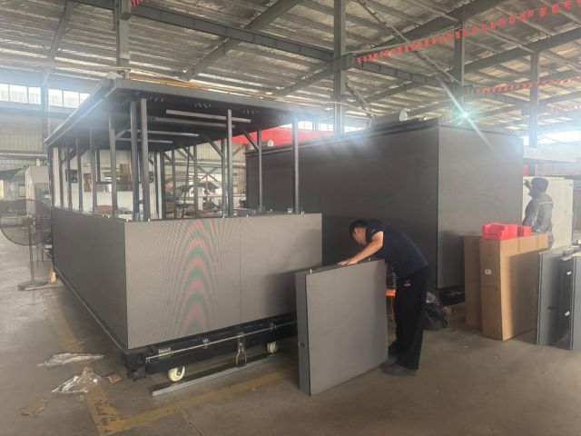 Technician mounting LED panels to the LED billboard truck structure